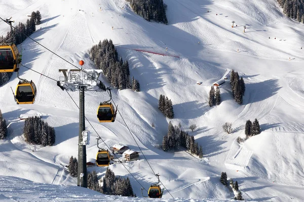 Gondola lift. Cabin of ski-lift in the ski resort in the early morning at dawn with mountain peak in the distance. Winter snowboard and skiing concept