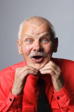 Gri bir arka plan üzerinde sürpriz bir emekli portresi