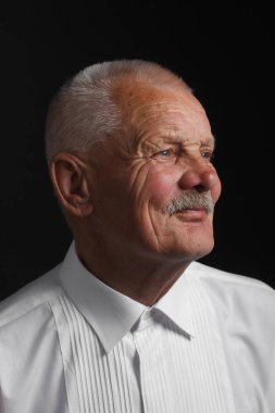 Siyah bir zemin üzerine beyaz gömlekli dalgın kıdemli