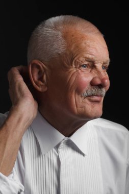 Siyah bir zemin üzerine beyaz gömlekli dalgın kıdemli