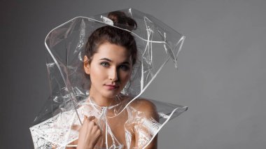 Şeffaf yağmur ceket güzel kadın. Gri arka planı