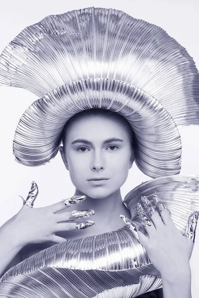 鉄の帽子と服と箔に包まれている指で未来的なスタイルで美しい女性 白背景 — ストック写真