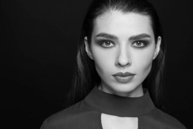Güzel bir olumlu kadının karanlık bir arka plan üzerinde siyah beyaz portre. Studio fotoğraf oturum