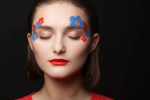 赤と青の花の形で化粧品で若い女の子の写真 黒の背景 — ストック写真