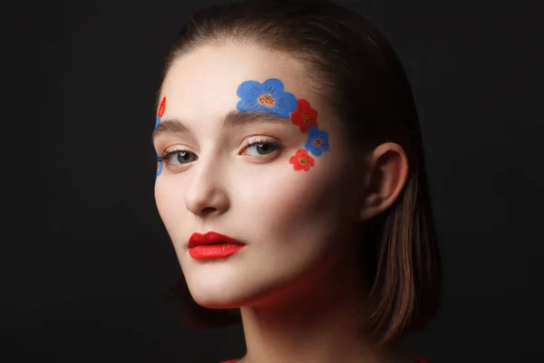 赤と青の花の形で化粧品で若い女の子の写真 黒の背景 — ストック写真