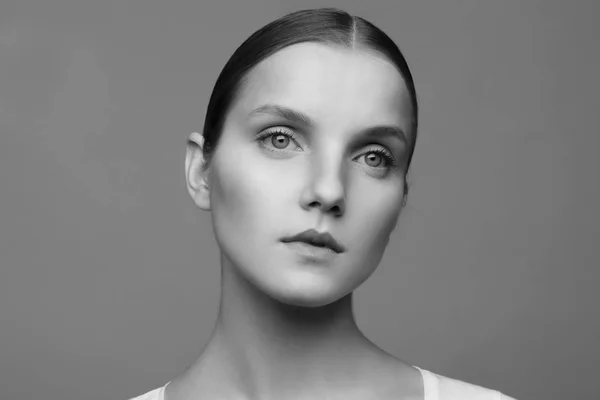 Retrato de cerca de una hermosa modelo con maquillaje limpio y cabello recogido, fotografiado en un estudio fotográfico —  Fotos de Stock