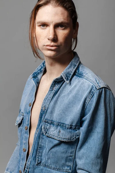 Retrato de un hombre guapo de pelo largo con pecas vestidas con una camisa de mezclilla — Foto de Stock