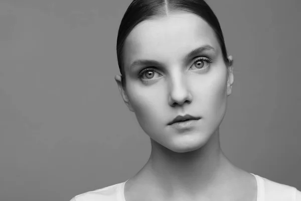 Retrato de cerca de una hermosa modelo con maquillaje limpio y cabello recogido, fotografiado en un estudio fotográfico — Foto de Stock