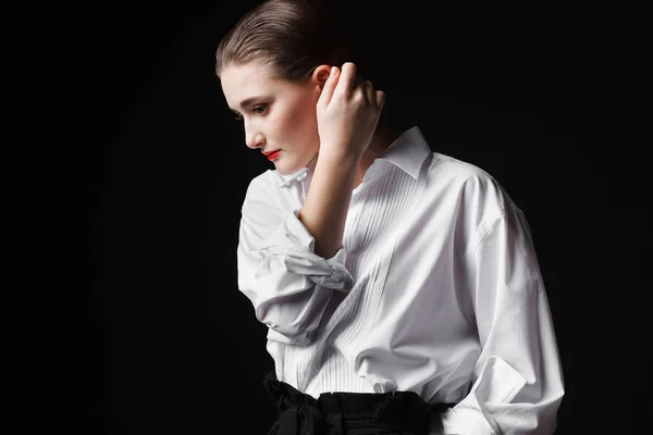 Retrato de una joven elegante con camisa blanca y pantalones negros. Interesante luz de estudio —  Fotos de Stock