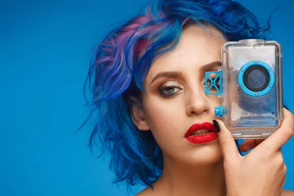 青とピンクの髪と赤い唇がプラスチック製のカメラのモックアップを保持している贅沢な女性の肖像画 — ストック写真