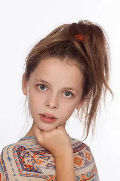 Menina bonita emocional de 8 anos, com o cabelo levantado e em uma blusa com ornamentos — Fotografia de Stock