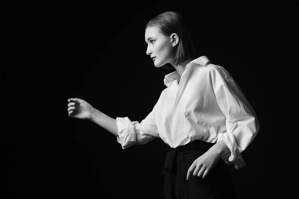 Retrato de uma jovem elegante com uma camisa branca e calças pretas. Luz de estúdio interessante — Fotografia de Stock