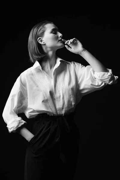 Retrato de una joven elegante con camisa blanca y pantalones negros. Interesante luz de estudio —  Fotos de Stock