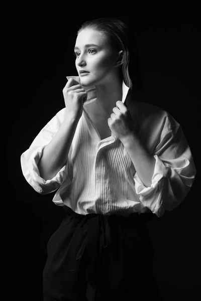 Retrato de una joven elegante con camisa blanca y pantalones negros. Interesante luz de estudio —  Fotos de Stock