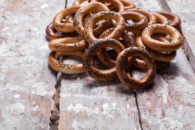 Lezzetli simit fotoğrafın haşhaş tohumu ile serpilir. Hafif ahşap arka plan