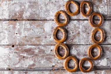 Lezzetli simit fotoğrafın haşhaş tohumu ile serpilir. Hafif ahşap arka plan