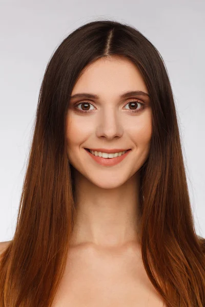 Portrait of a beautiful woman with straight long hair and interesting emotion. Light gray background — Stock Photo, Image