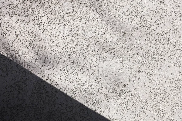 Fotografía en blanco y negro de la pared exterior de hormigón de la casa con roce y sombra . — Foto de Stock