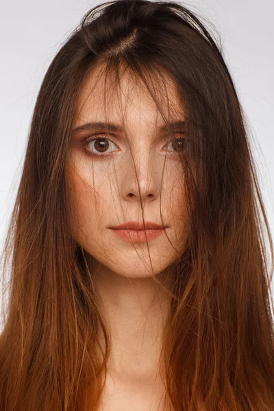 Retrato de una mujer hermosa con el pelo largo liso y emoción interesante. Fondo gris claro — Foto de Stock