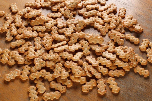 Composizione di cracker con semi di papavero, distribuiti su uno sfondo di legno — Foto Stock