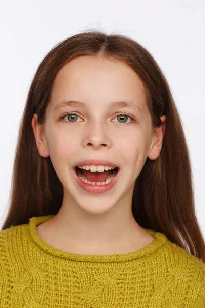 Emotionales Porträt eines fröhlichen achtjährigen Mädchens im gelb-grünen Pullover — Stockfoto