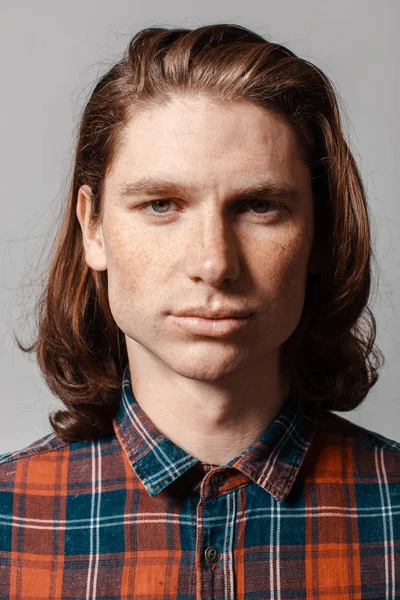 Portrait d'un homme aux cheveux longs et aux taches de rousseur, vêtu d'une chemise à carreaux — Photo
