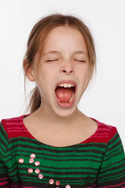 Retrato de uma menina de 8 anos gritando em uma camisola em riscas carmesim e verde — Fotografia de Stock