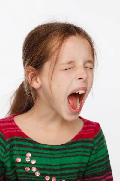 Retrato de uma menina de 8 anos gritando em uma camisola em riscas carmesim e verde — Fotografia de Stock