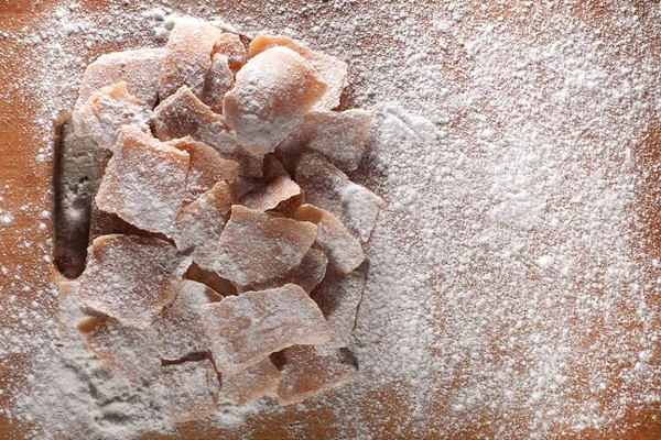 Foto di caramelle alla frutta da mele, cosparse di zucchero a velo e disposte su tavole di legno — Foto Stock