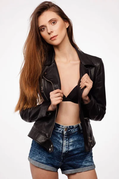 Портрет красивой сексуальной модели в черной кожаной куртке, бюстгальтере и джинсовых шортах — стоковое фото
