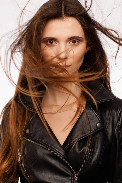 Portrait of a beautiful sexy model in black leather jacket. Hair in the wind