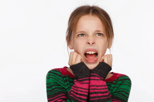 Retrato de uma menina de 8 anos gritando em uma camisola em riscas carmesim e verde — Fotografia de Stock