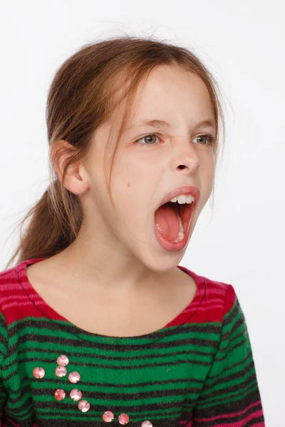 Retrato de uma menina de 8 anos gritando em uma camisola em riscas carmesim e verde — Fotografia de Stock