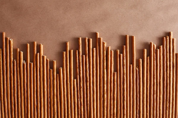 Crispy bread straw on brown paper background