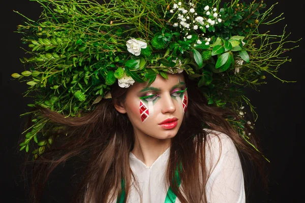 Portrait of a beautiful woman in a white dress with a green ribbon and with branches on her head. Creative makeup — Stock Photo, Image