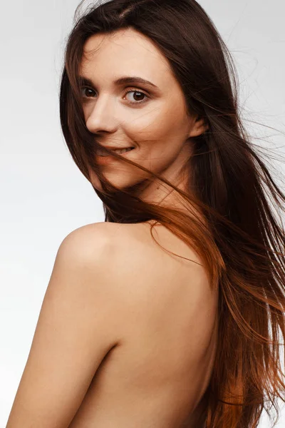 Retrato de una joven hermosa mujer con el pelo volando del viento y hombros desnudos — Foto de Stock