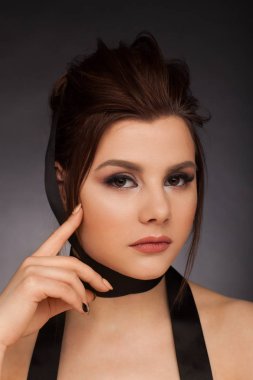 Siyah kurdeleli esmerin dramatik portresi. Stüdyo fotoğraf oturumu