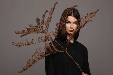 Siyah giysiler ve kuru eğrelti otu ile sıkı bir model Portresi