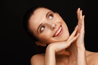 Siyah bir arka plan üzerinde toplanan saç ve çıplak omuzları ile güzel bir kadının portresi
