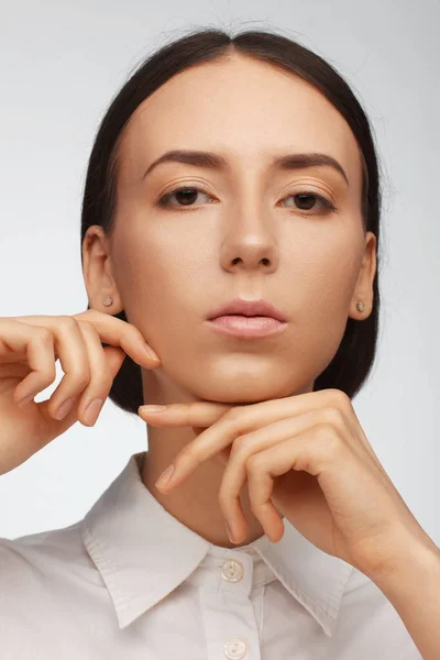 Retrato de una hermosa mujer pacificada con una camisa blanca sobre un fondo claro — Foto de Stock