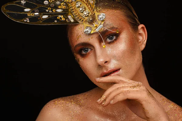 Portrait of a beautiful woman with expressive creative make-up in bronze and with a decoration on her head — Stock Photo, Image