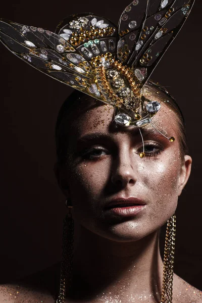 Portrait of a beautiful woman with expressive creative make-up in bronze and with a decoration on her head — Stock Photo, Image