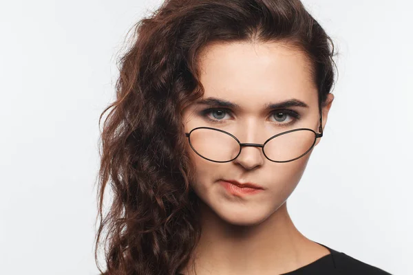 巻き毛と眼鏡を持つ美しいインテリジェントな女性の肖像画。スタジオフォトセッション — ストック写真