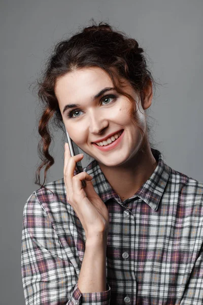 곱슬 머리와 그녀의 손에 전화와 지능형 학생의 초상화. 체크 셔츠 — 스톡 사진