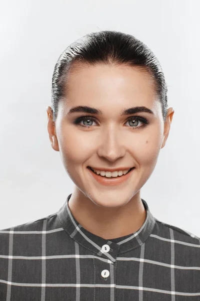 Retrato de uma menina em uma camisa xadrez cinza e com cabelo coletado — Fotografia de Stock