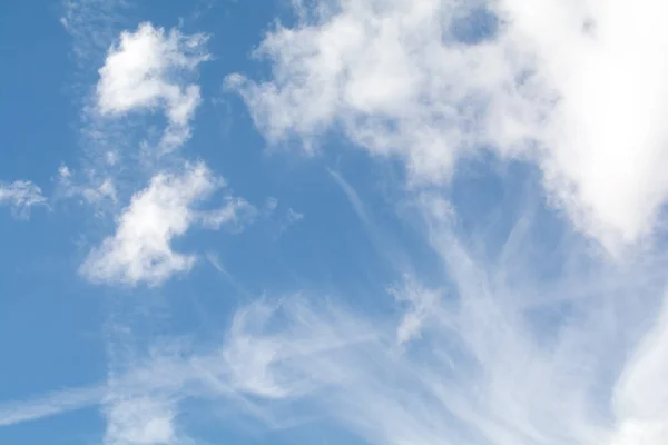 stock image Whispy white clouds over a blue sky background