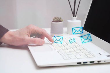 Ofisinden e-postalar göndermek için bir dizüstü bilgisayar kullanan adam