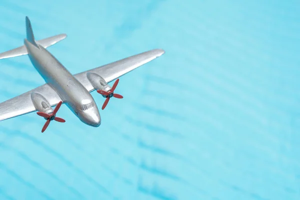 Toy plane flys high above for travel and transport concept with — Stock Photo, Image