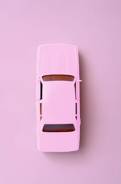 Pink toy car on minimal pink background