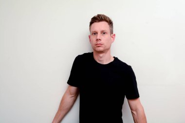 Adam doğrudan kameraya bakıyor, model gülümseyerek değil ve f bakan